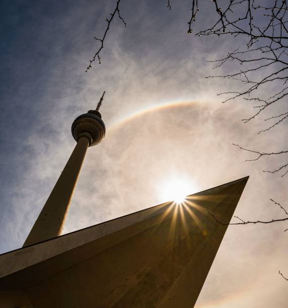 um anjo baixo tiro da torre de televisão de berlim com sol e um arco-íris - berlin germany television tower communications tower alexanderplatz - fotografias e filmes do acervo