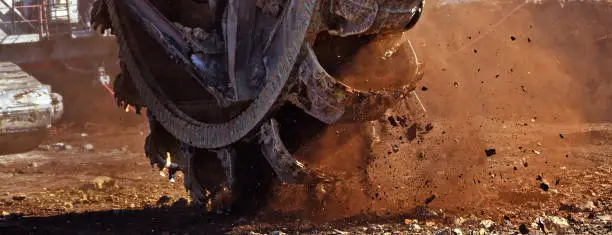 Photo of Bucket-wheel excavator during excavation at the surface mine. Huge excavator on open pit mine.