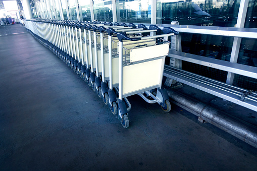 Row of airport push cart at outdoor entrance of airport