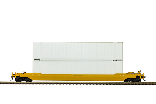 A yellow double stack intermodal railroad car on track.