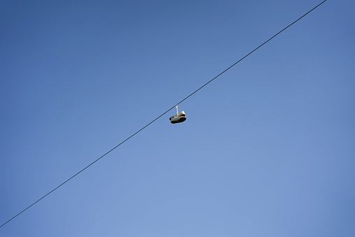 Pair of shoes hanging on electric street cables