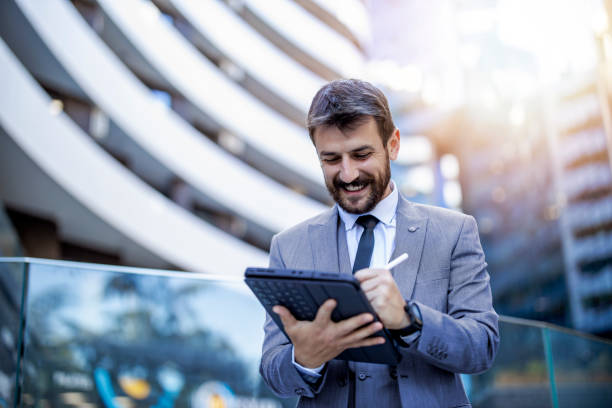 Young businessman using a digital tablet outdoors stock photo