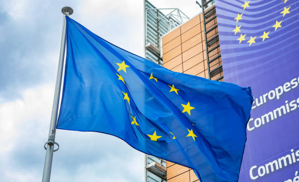 bandiera dell'unione europea davanti all'edificio berlaymont, sede della commissione europea. - euro symbol european union currency currency banking foto e immagini stock