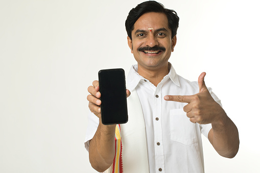 Smiling south indian man showing blank mobile phone screen