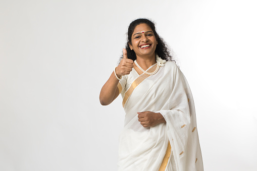 Smiling south indian woman in sari showing thumbs up