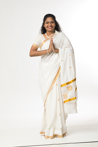 Smiling south indian woman in sari greeting with prayer pose