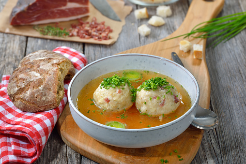 Delicious South Tyrolean bacon dumplings soup with hot beef broth and chives