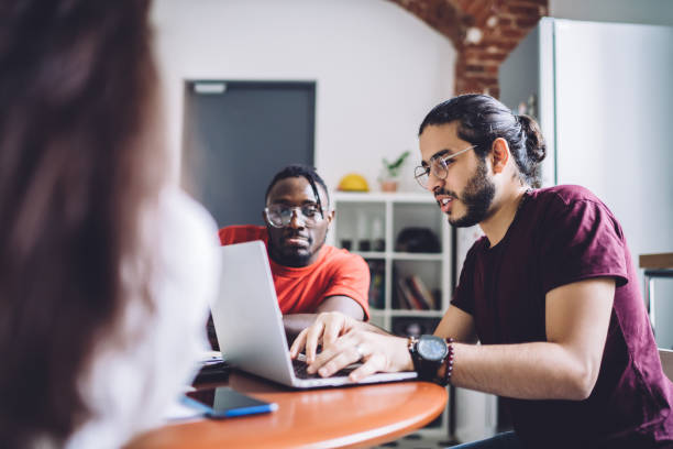 istock Young creative freelancers having meeting and using laptop 1453128260