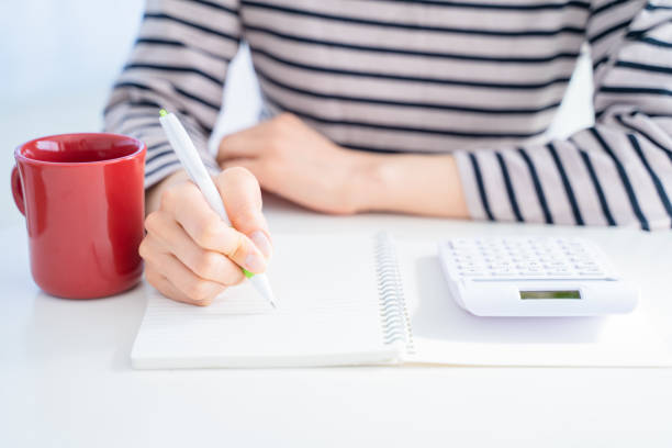 istock A woman's hand with a household account book. 1453130306