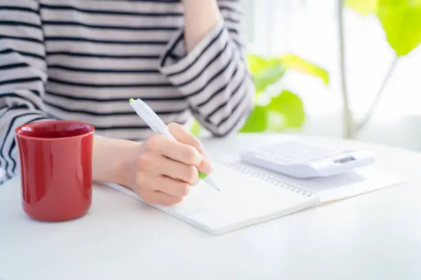 A woman's hand with a household account book.