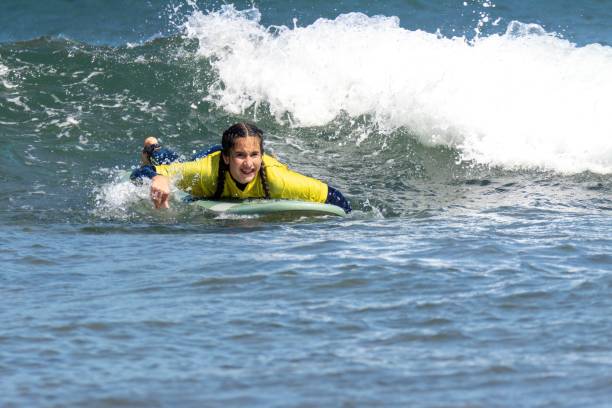 istock Young smiley woman surfing on the sea 1453130509