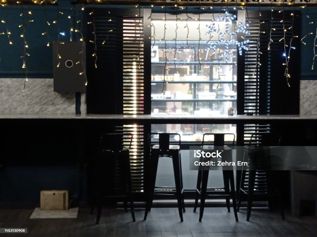 A cafe with Christmas lights at night Concept photo, dark cafe with bright Christmas decorations and a snowflake ornament at night Cafe Stock Photo