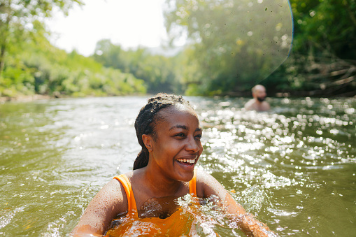 Photo of a smiling woman swimming in the river