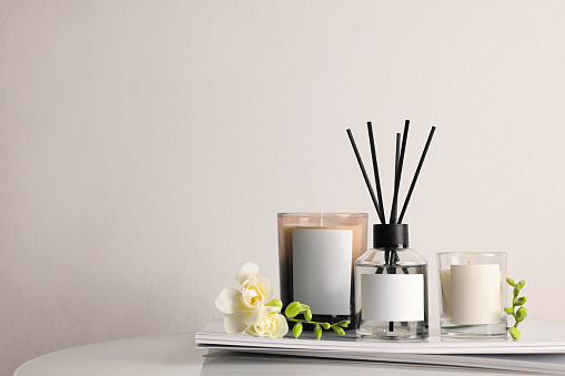 Composition with aromatic reed air freshener on white table, space for text