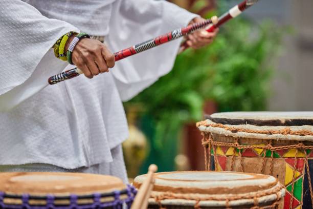 istock African drummer holding drumsticks and playing on the park on a sunny day 1453137938