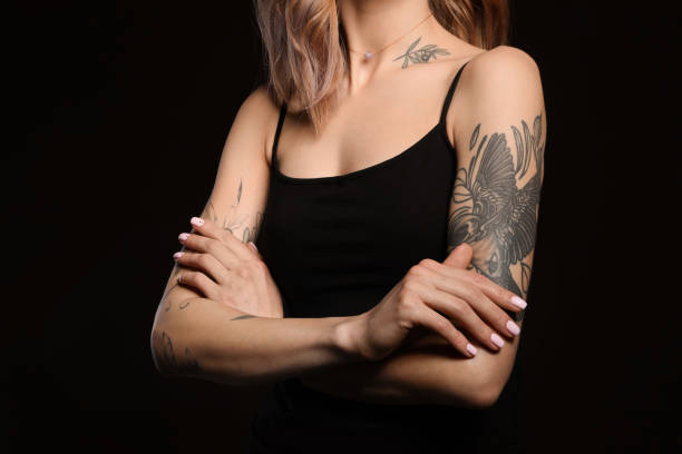 bella donna con i tatuaggi sul corpo contro lo sfondo nero, primo piano - tattoo women bird shoulder foto e immagini stock