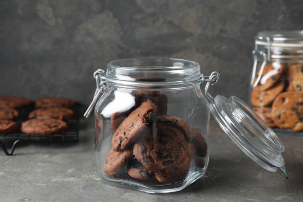 istock Delicious chocolate chip cookies in glass jar on grey table 1453138129