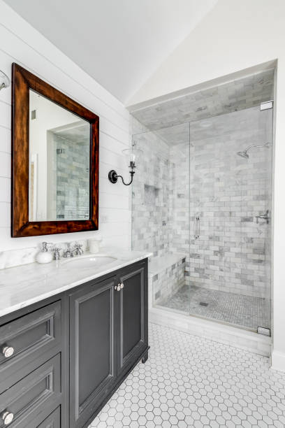 A rustic bathroom with a grey cabinet, shiplap wall, and marble subway tile shower.