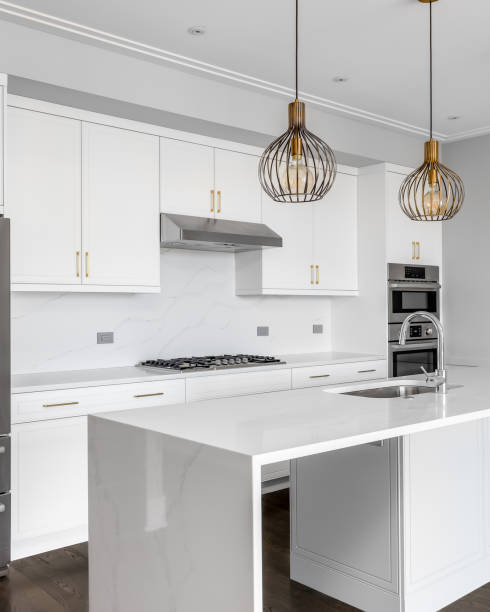 istock A white kitchen with gold lights hanging above the island. 1453138299