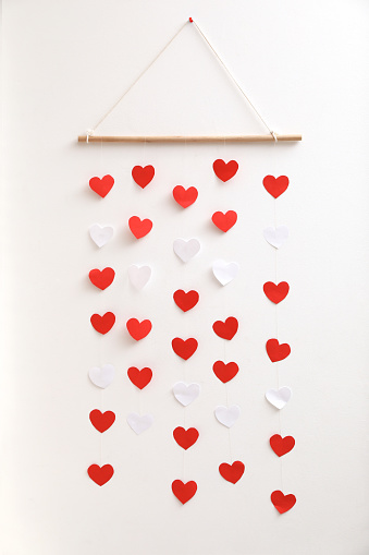 Beautiful decor element with hearts on white wall. Valentine's Day celebration