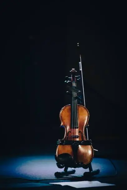 Photo of Vertical shot of a cello on the stage with a dark background