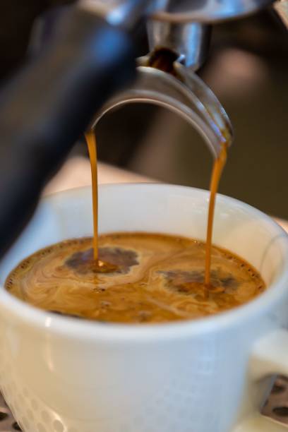 istock Vertical closeup of the machine pouring coffee into the cup. 1453140689