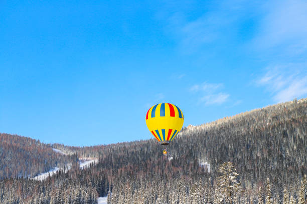 istock flying yellow hot air balloon over winter mountains 1453141665