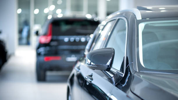 New cars at dealer showroom New cars at dealer showroom. Blurred background. Focus is on the right exterior mirror empty dealership interior stock pictures, royalty-free photos & images