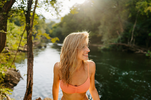 Photo of a smiling woman on a river bank