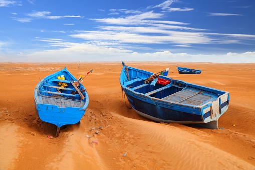 Morocco tourist attraction. Desert fishing boat in the sand near Essaouira beach.
