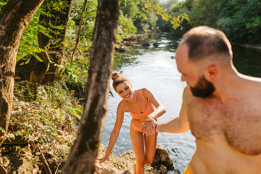 Photo of a happy couple on a river bank