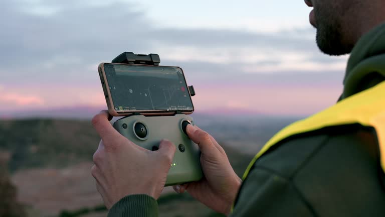 Close-up of a man controlling a drone at sunset