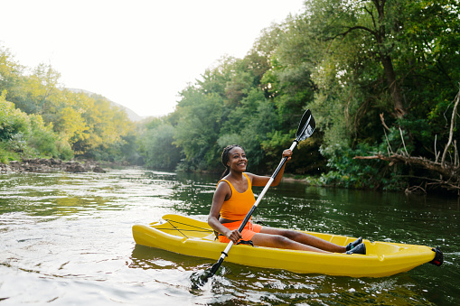 Photo of a beautiful woman kayaking alone on a summer day