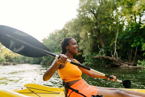 Photo of a beautiful woman kayaking alone on a summer day