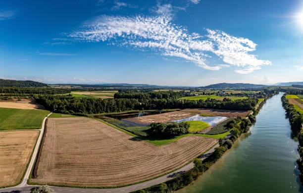 istock Beautiful view of fields by the river under the blue sky during sunset 1453153134