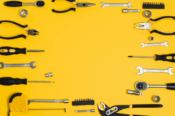istock Yellow and black handy tools (pilers and screwdriver) isolated on yellow background. 1453153391