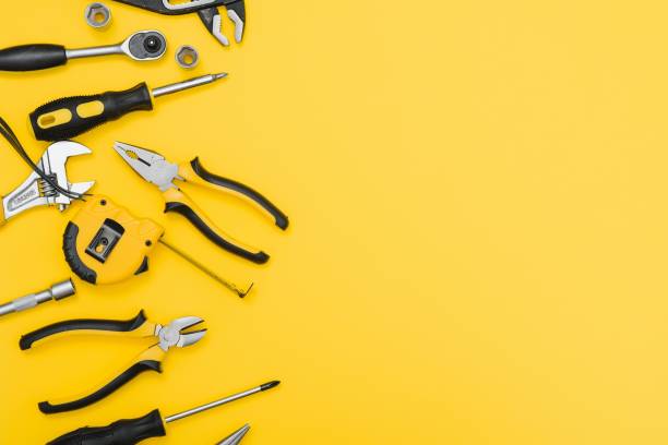 istock Yellow and black handy tools (pilers and screwdriver) isolated on yellow background 1453154591