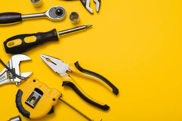 istock Yellow and black handy tools (pilers and screwdriver) isolated on yellow background. 1453154660