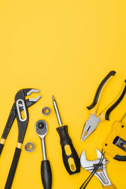 istock Yellow and black handy tools (pilers and screwdriver) isolated on yellow background. 1453154757