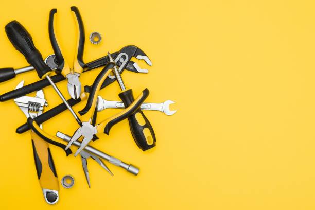 istock Yellow and black handy tools (pilers and screwdriver) isolated on yellow background. 1453154758