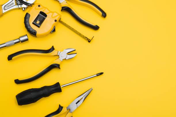 istock Yellow and black handy tools (pilers and screwdriver) isolated on yellow background. 1453154760