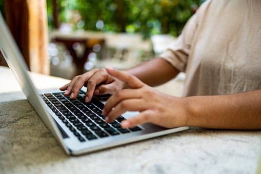 Close up on human hand using the keyboard laptop