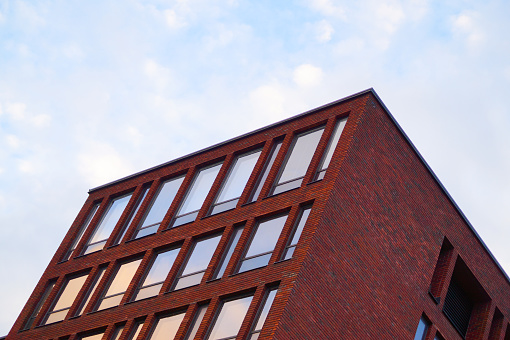 Low angle view of modern brick building against sky