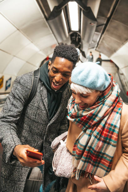 istock Couple looking social media on the subway escalator 1453165626