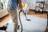 Old man vacuuming at home