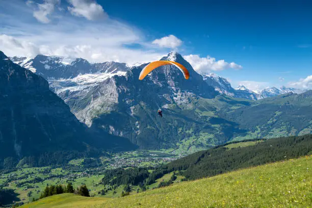 Tandem Paragliding over the village of Grindelwald with The Eiger mountain and Swiss alps in the background.