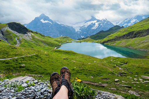 Hiker resting and enjoying the view of the Swiss Alps near Bachalpsee.