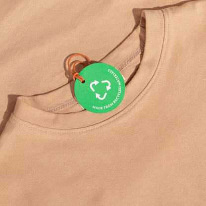 Beige tshirt and Green paper label with inscription 