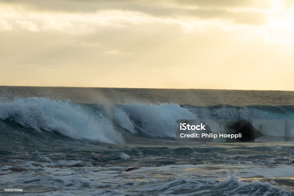Huge waves on a beautiful morning in Madeira, Portugal. Great sunrise and a beautiful yellow sky over the tsunami. Wonderful landscape in Portugal, Madeira. Aerial View Stock Photo