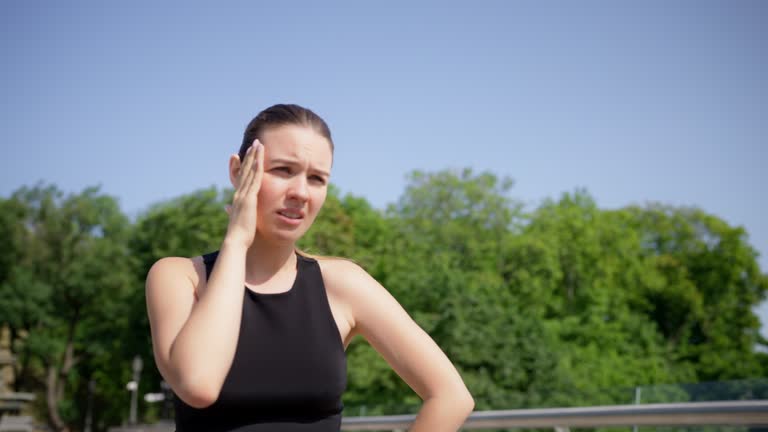 Young woman feeling dizziness during her morning run, health problems, migraine